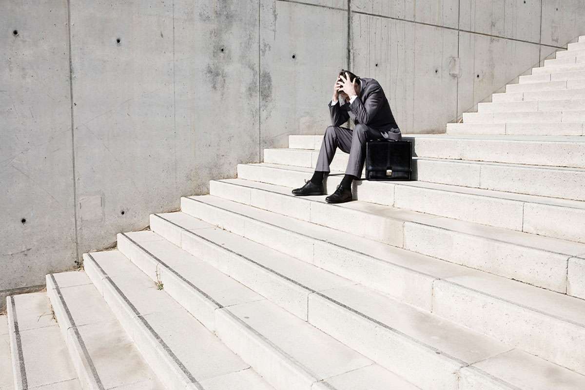 مرد دچار حمله پانیک یک مرد روی پله ها نشسته و حمله پانیک به وی دست داده است