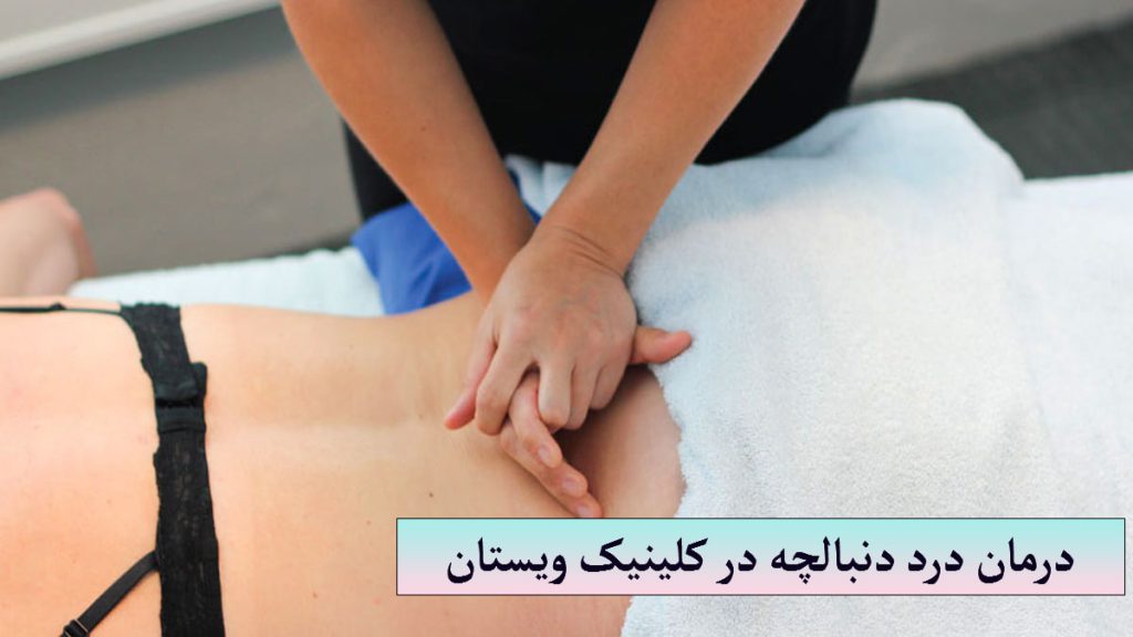 یک پزشک در حال درمان مشکل دنبالچه فرد بیمار